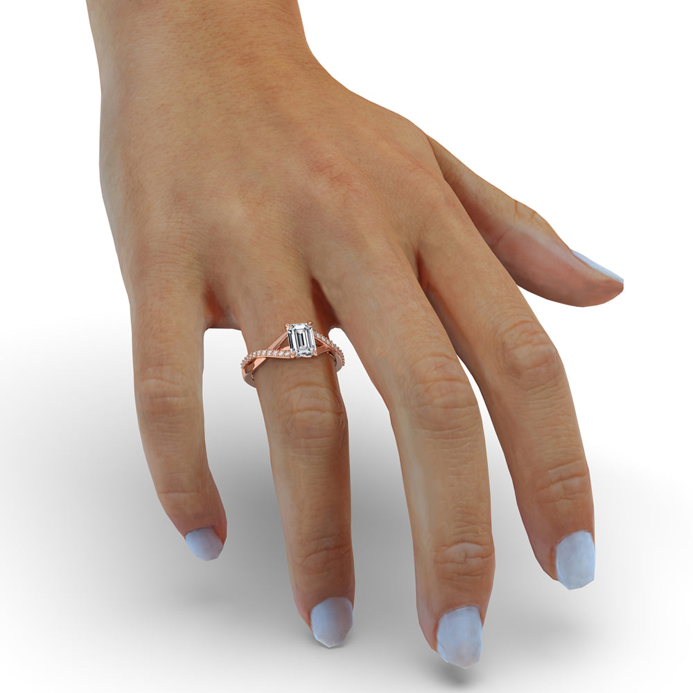 Emerald engagement ring with claw prongs and a twist engagement ring design for added charm.