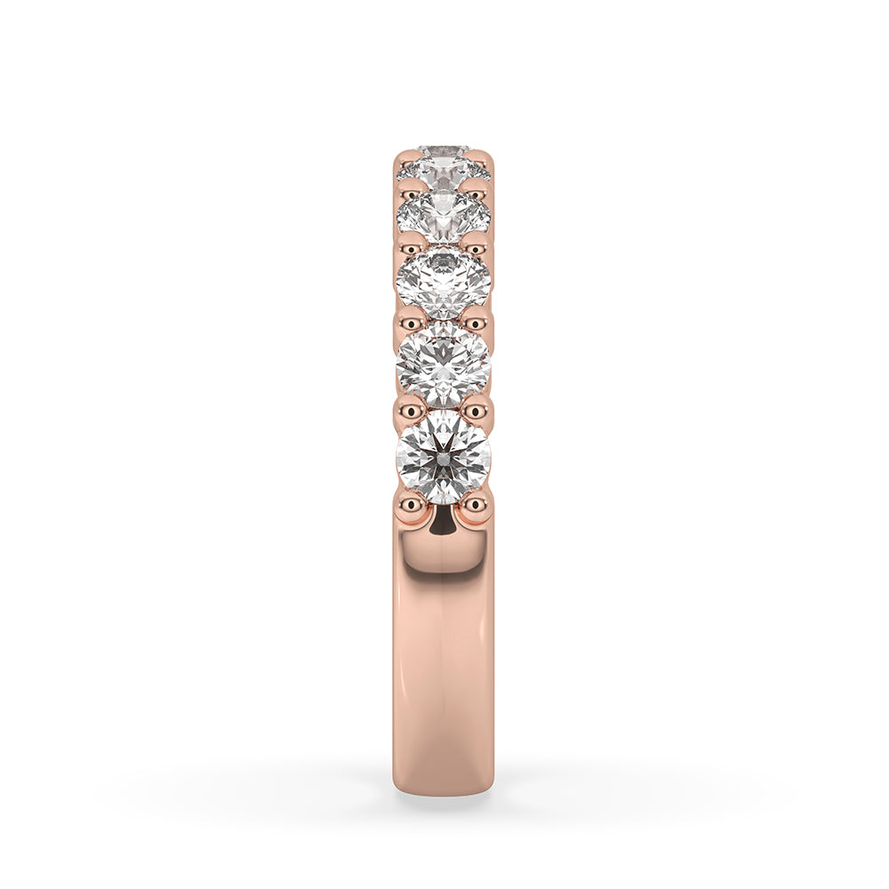 Rose gold wedding band featuring a round diamond eternity band for elegance.
